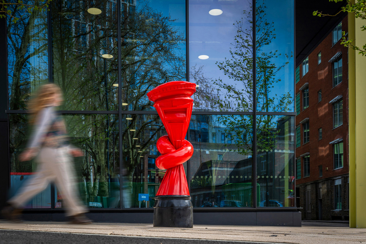 A traditional British post box tied in a knot has been joined by a twisted red telephone box and a pair of lamp posts tied in a bow.
