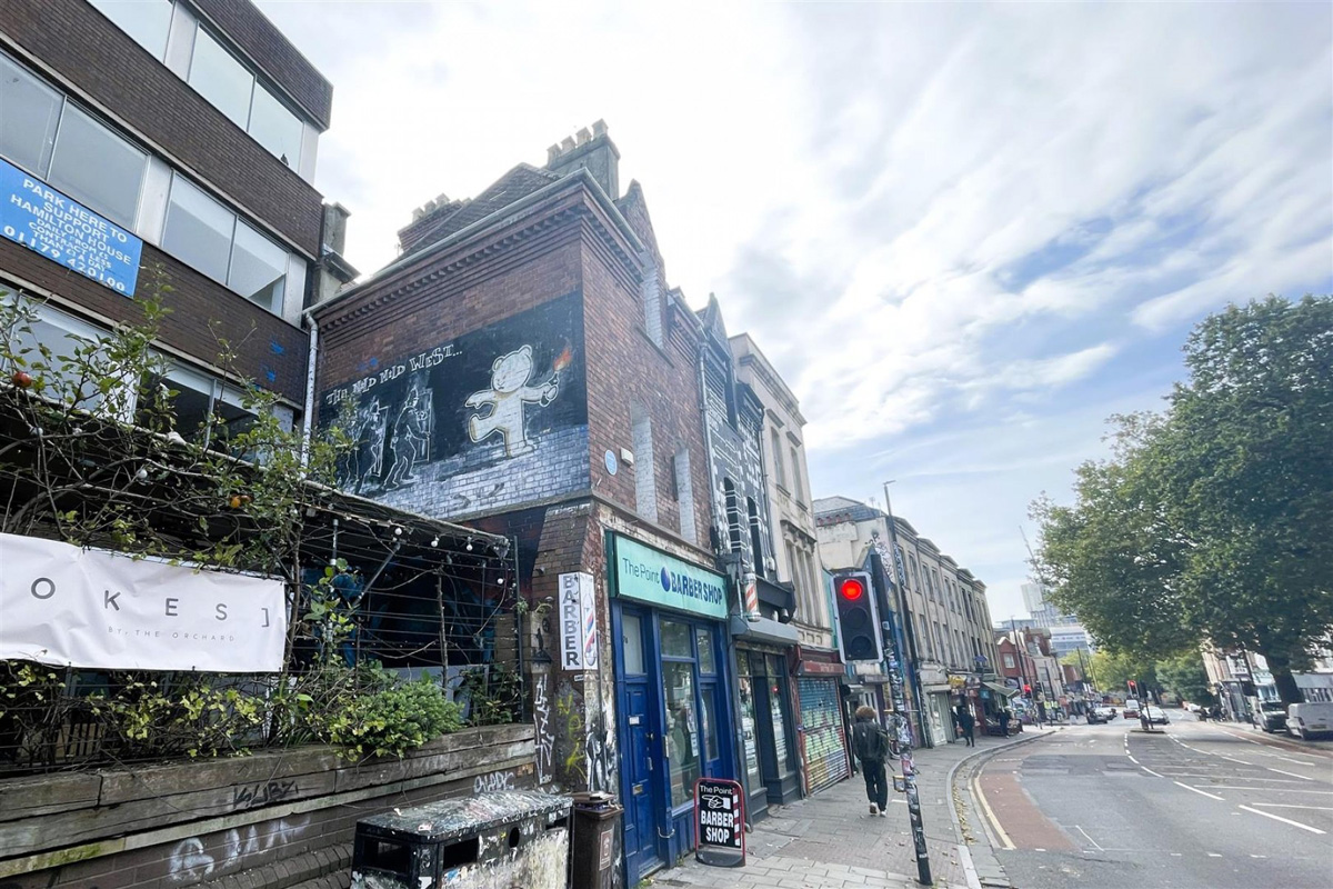 An unassuming Bristol city centre retail unit with flats above and an art world twist has sold at auction.
